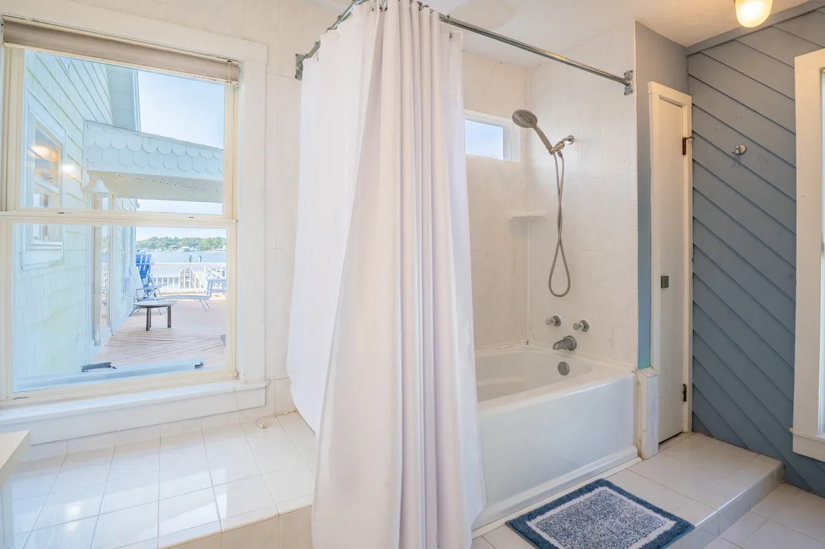 A tranquil bathroom with a bathtub and walk-in shower, set beside a window offering scenic views. The gentle light and serene finishes create a spa-like ambiance perfect for relaxation after a day of adventure.