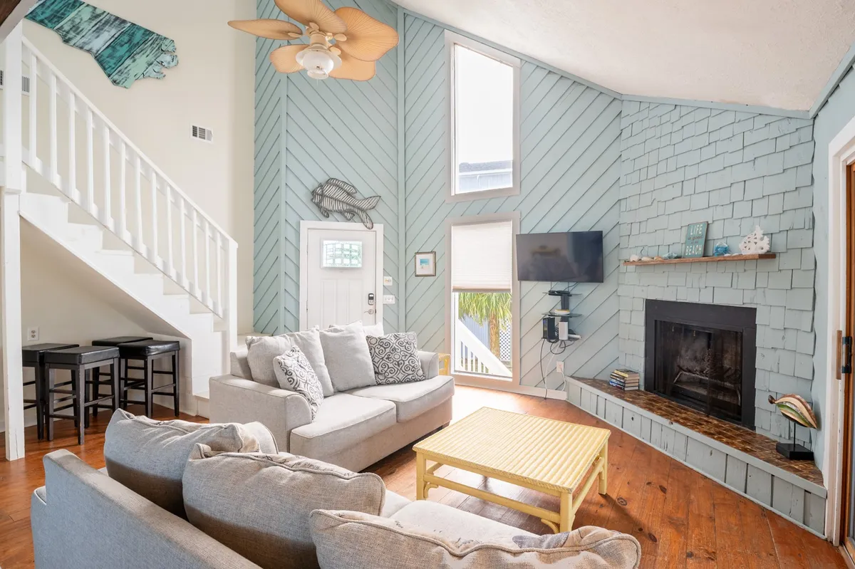 This cozy living room features a sofa, coffee table, fireplace, tasteful wall decor, and large windows. The environment is warm and inviting, perfect for relaxing after a day of exploration or enjoying evening gatherings.